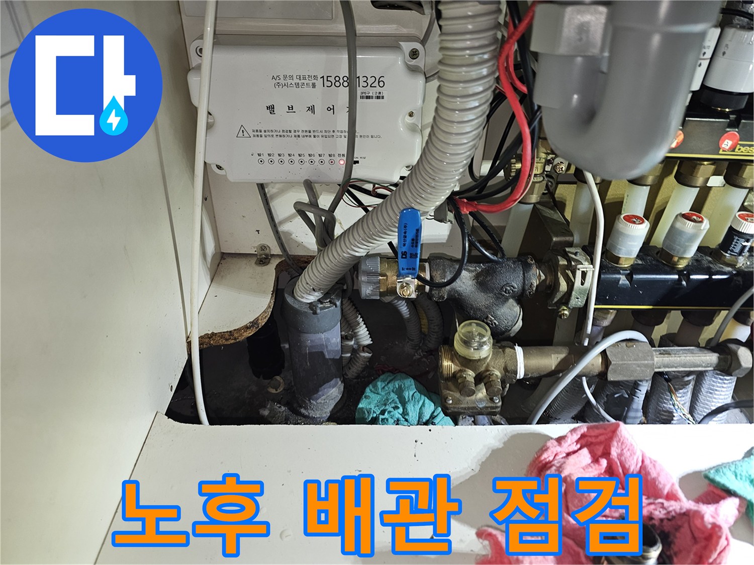 싱크대 아래 설치된 난방 밸브와 보온재 마감 배관