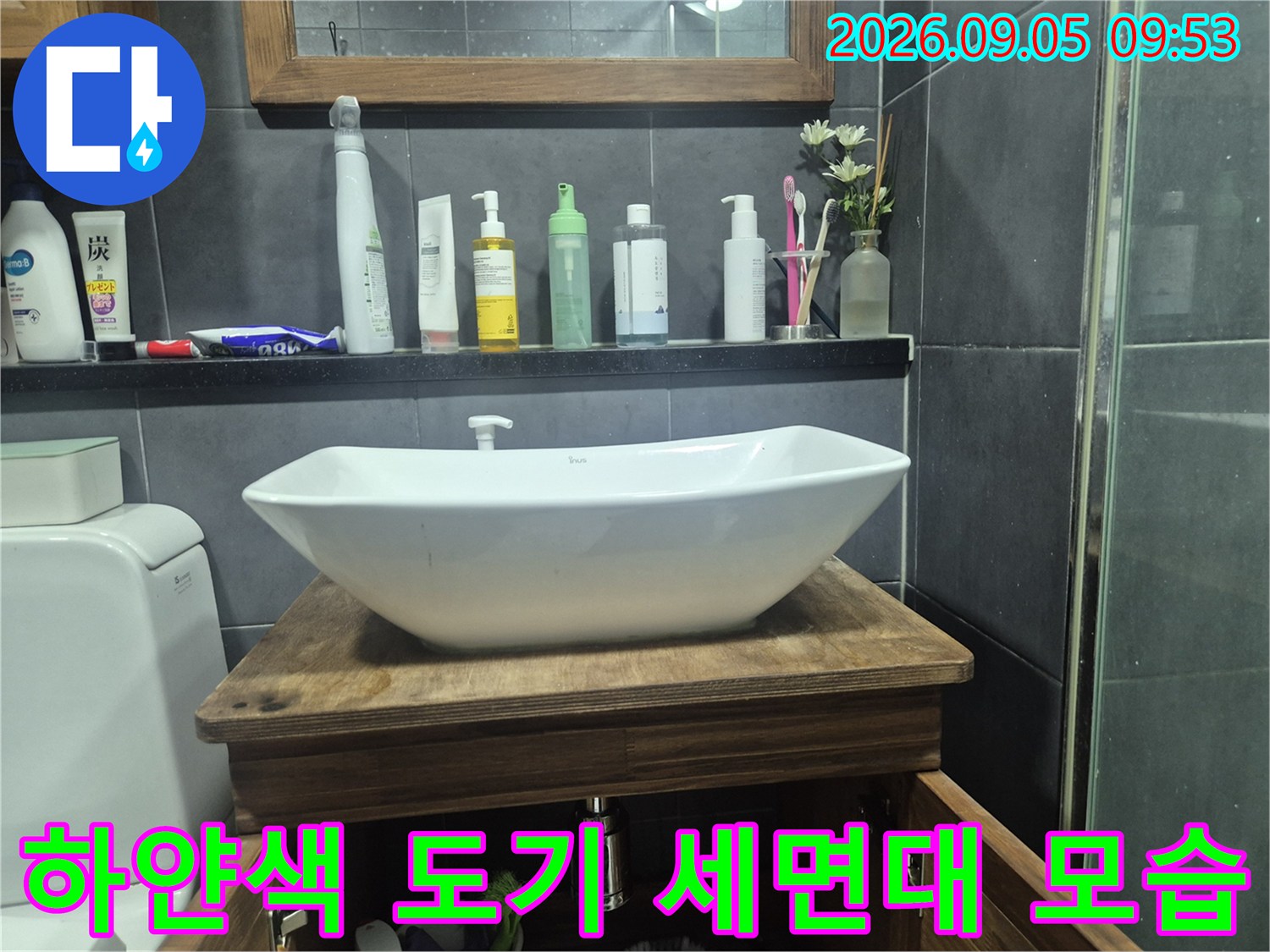 욕실 선반의 세정제들과 하얀색 세면대 상단부