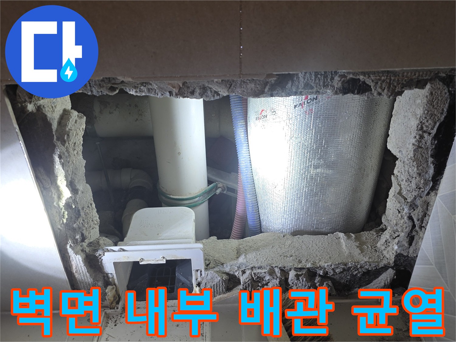 타일 안쪽 배관 연결 부위의 누수 흔적과 파손 상태