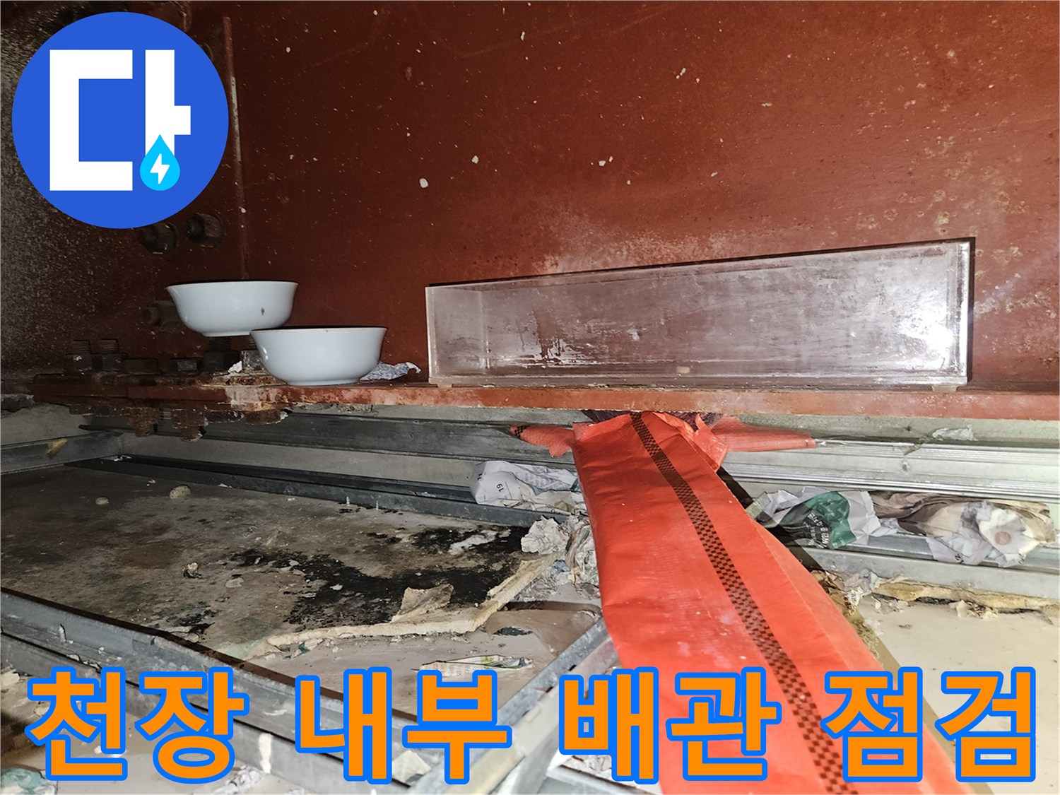 천장 개방 부위의 붉은색 보온 배관과 오염된 구조물