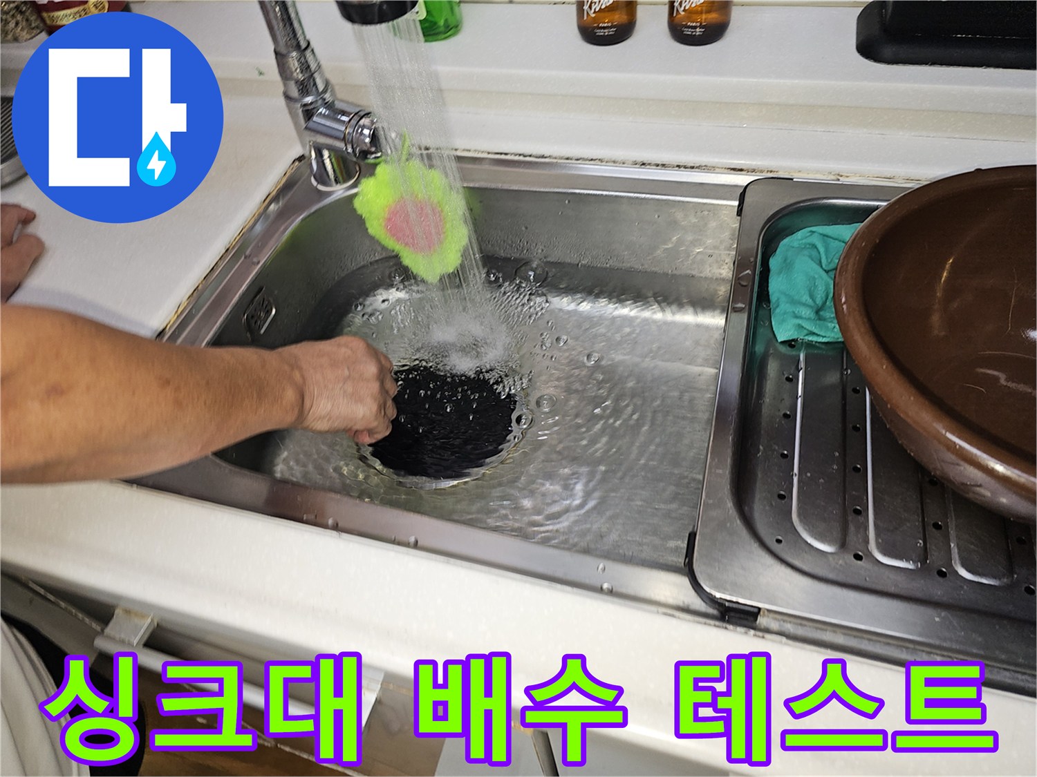싱크대 수전에서 쏟아지는 물이 배수구를 통과하는 장면