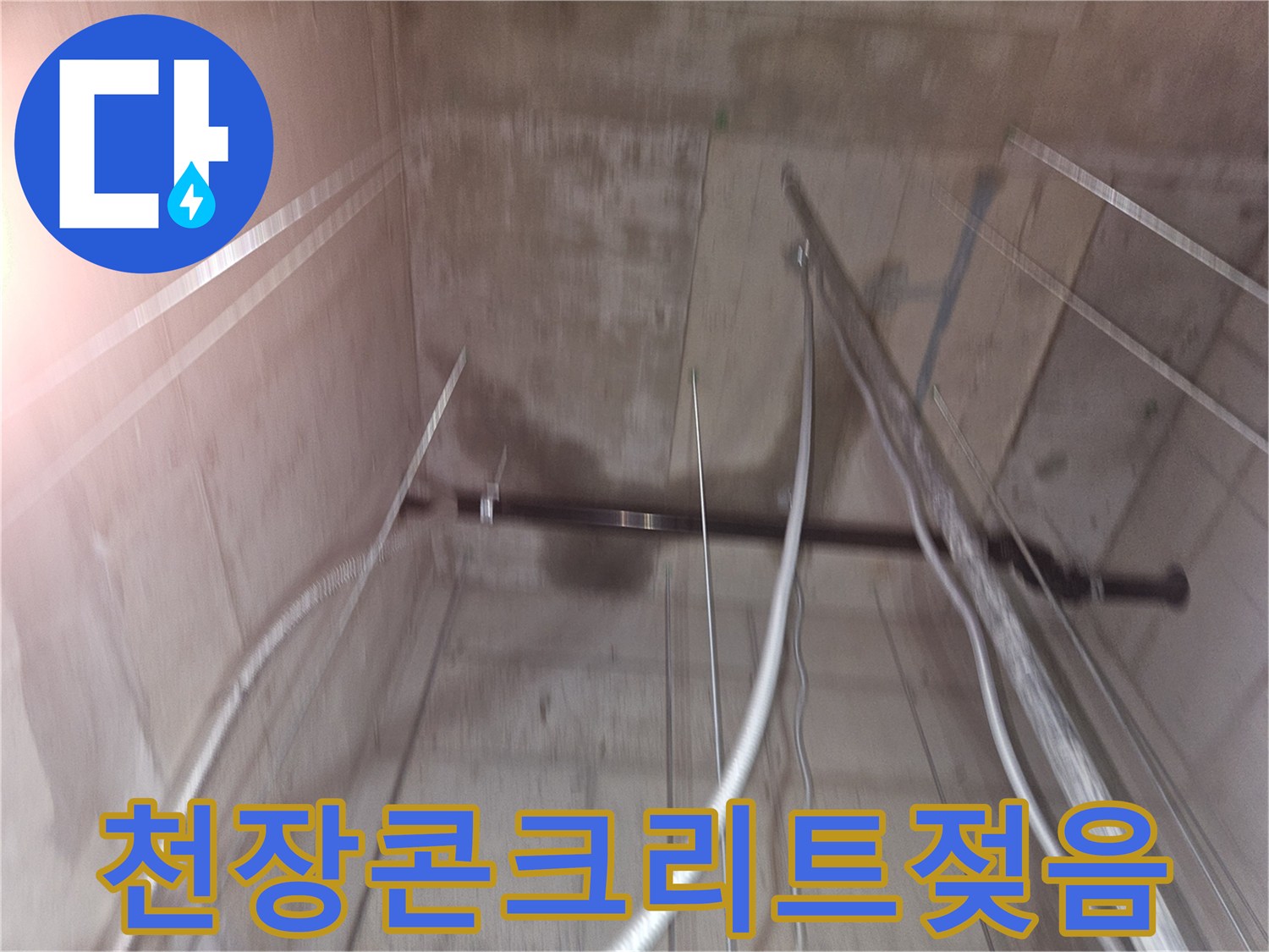 습기로 인해 어둡게 변색된 지하 천장 콘크리트와 노출된 배관 라인