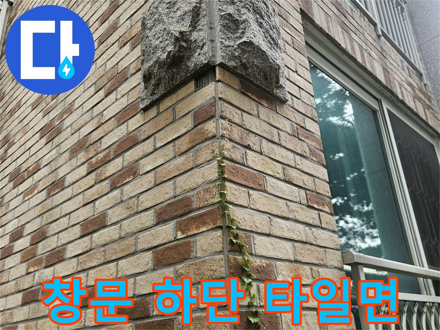 창문 아래쪽의 베이지색 타일과 벽돌 마감 부위 촬영