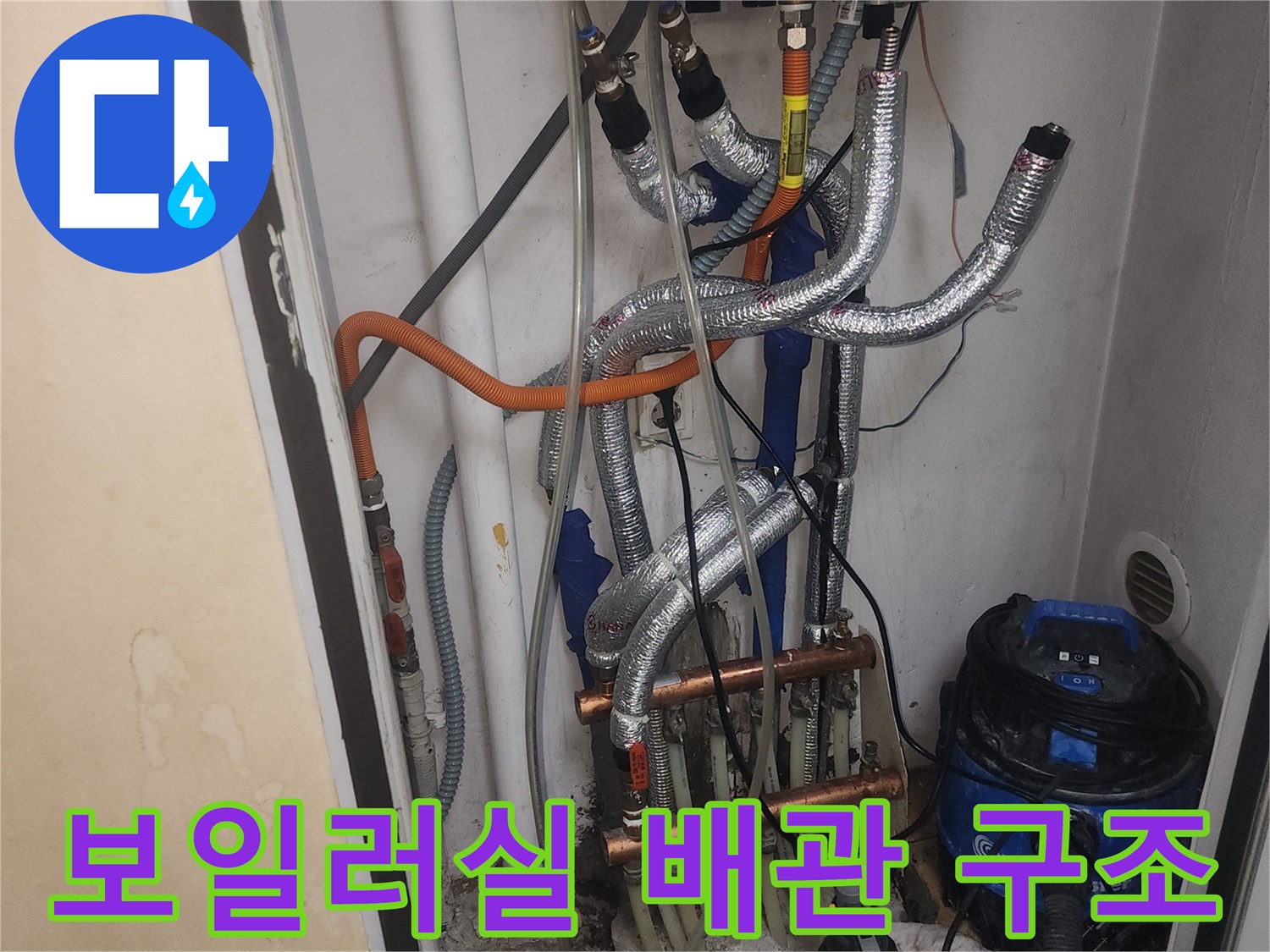 보일러와 연결된 금속 분배기와 은색 보온재가 씌워진 다양한 배관들