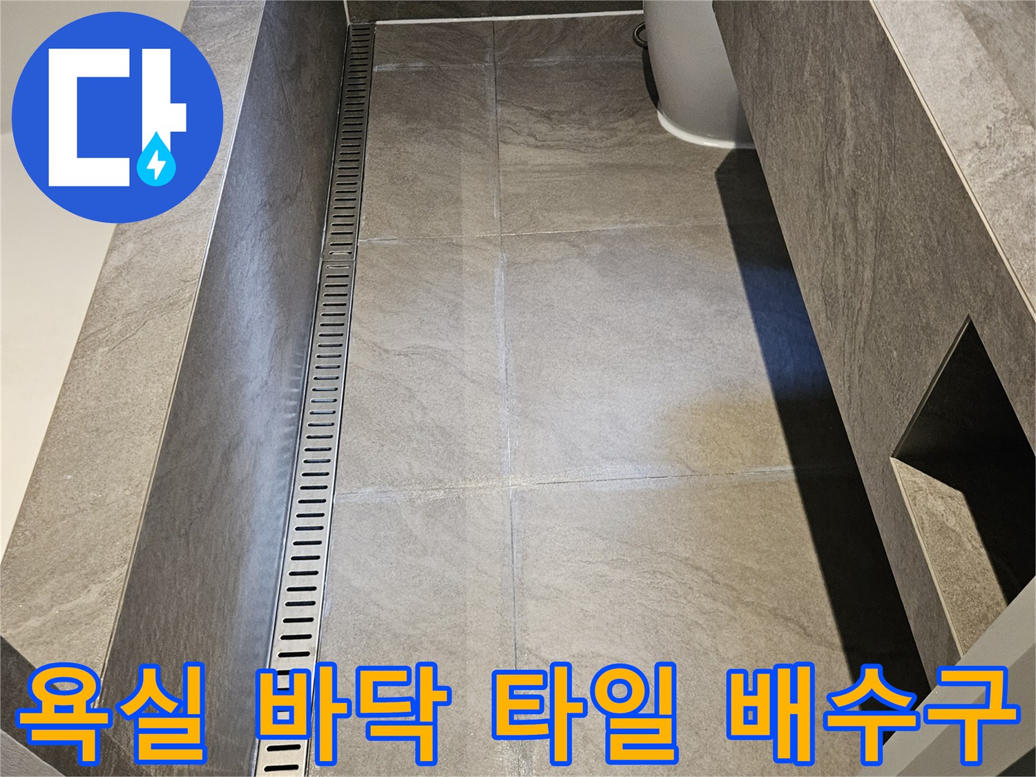 긴 형태의 스테인리스 트렌치와 대리석 타일 마감