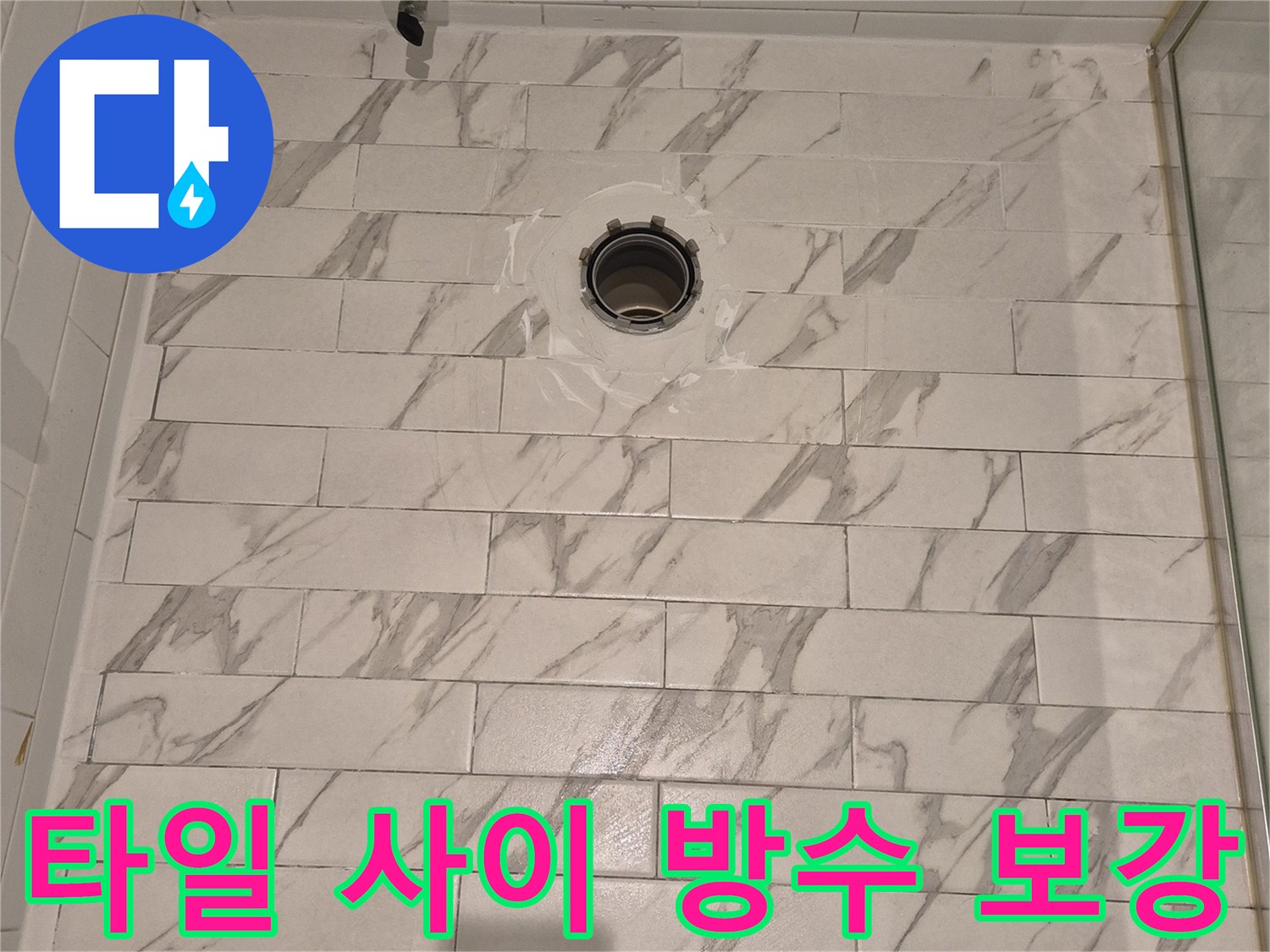 하얀색 마블 타일 사이의 배수구 정심 부위 작업 사진입니다.