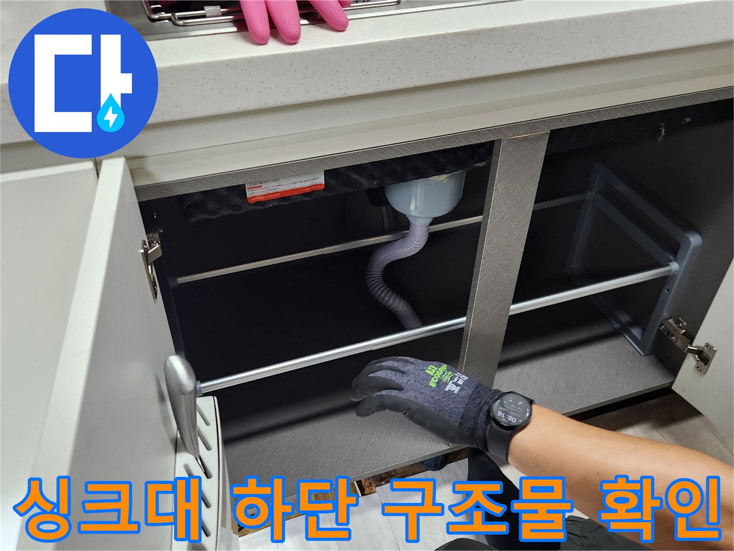 싱크대 밑 공간의 배수 호스와 하부장 내부 모습