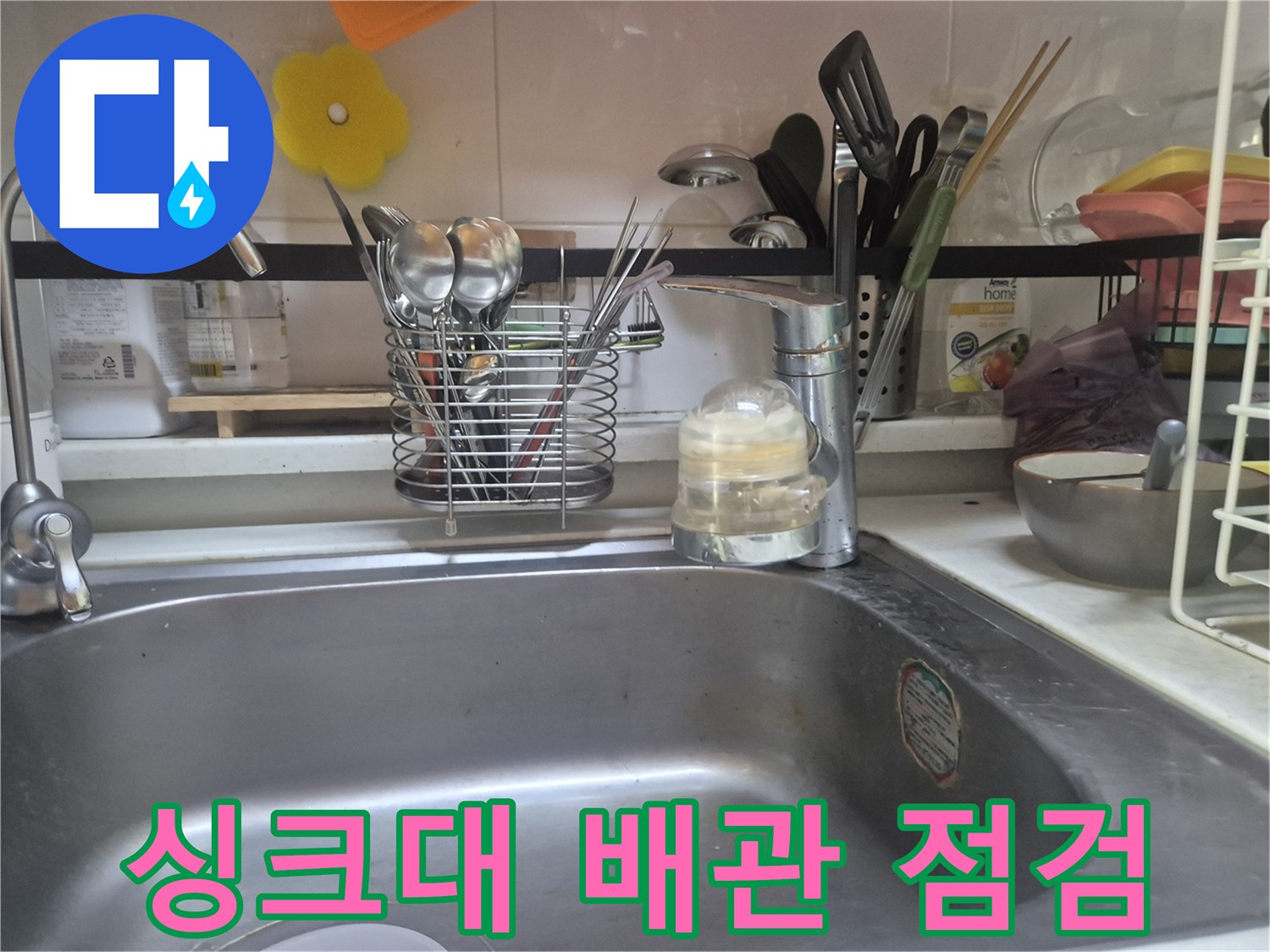 싱크대 하단 수전 연결 부위의 누수 여부를 확인하는 모습