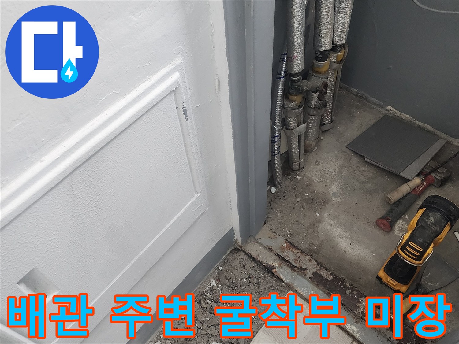 노출된 배관 주위를 시멘트로 채우는 건설 현장 모습입니다.