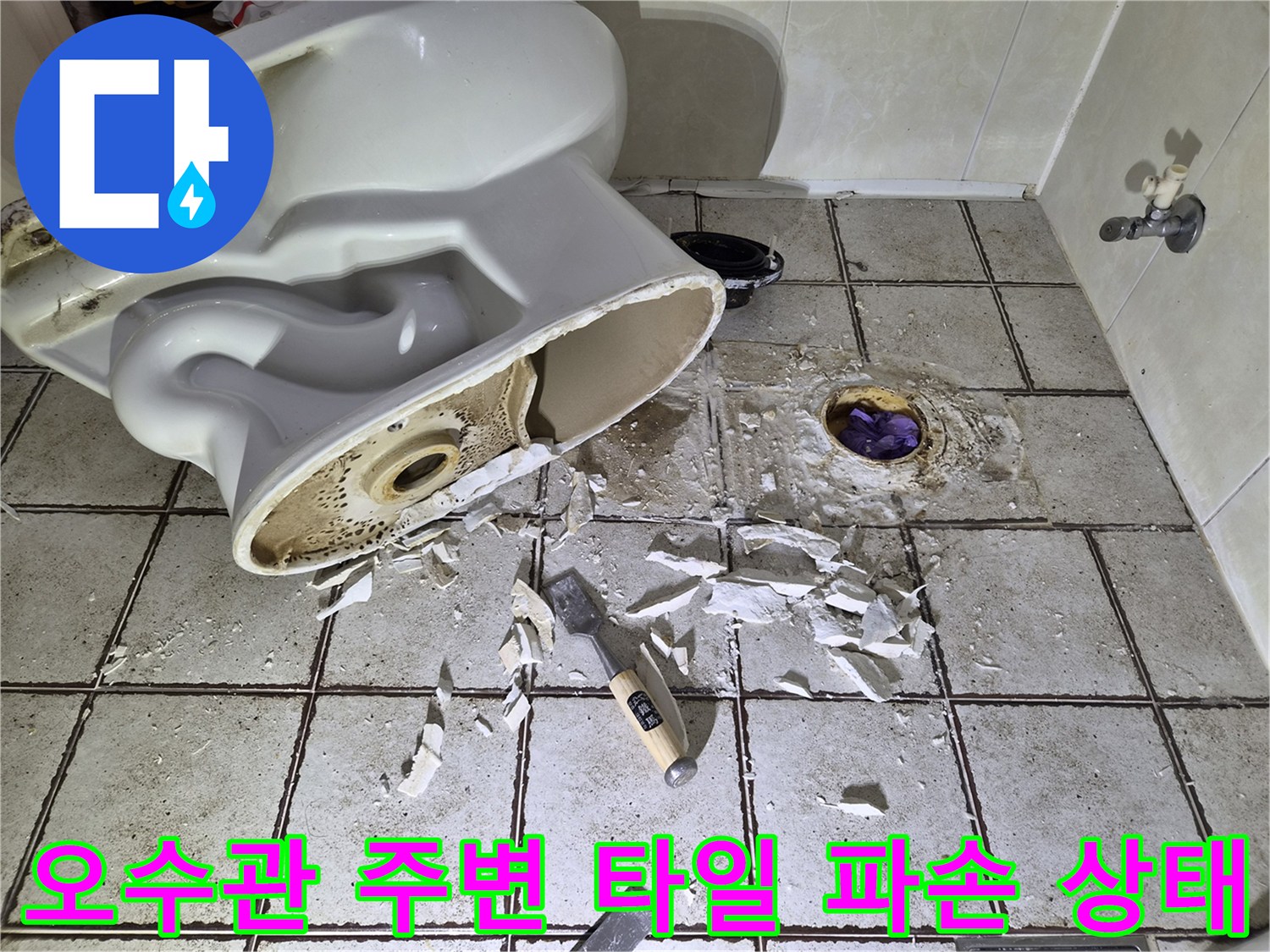 양변기를 탈거하여 노출된 오수관과 깨진 타일 조각들