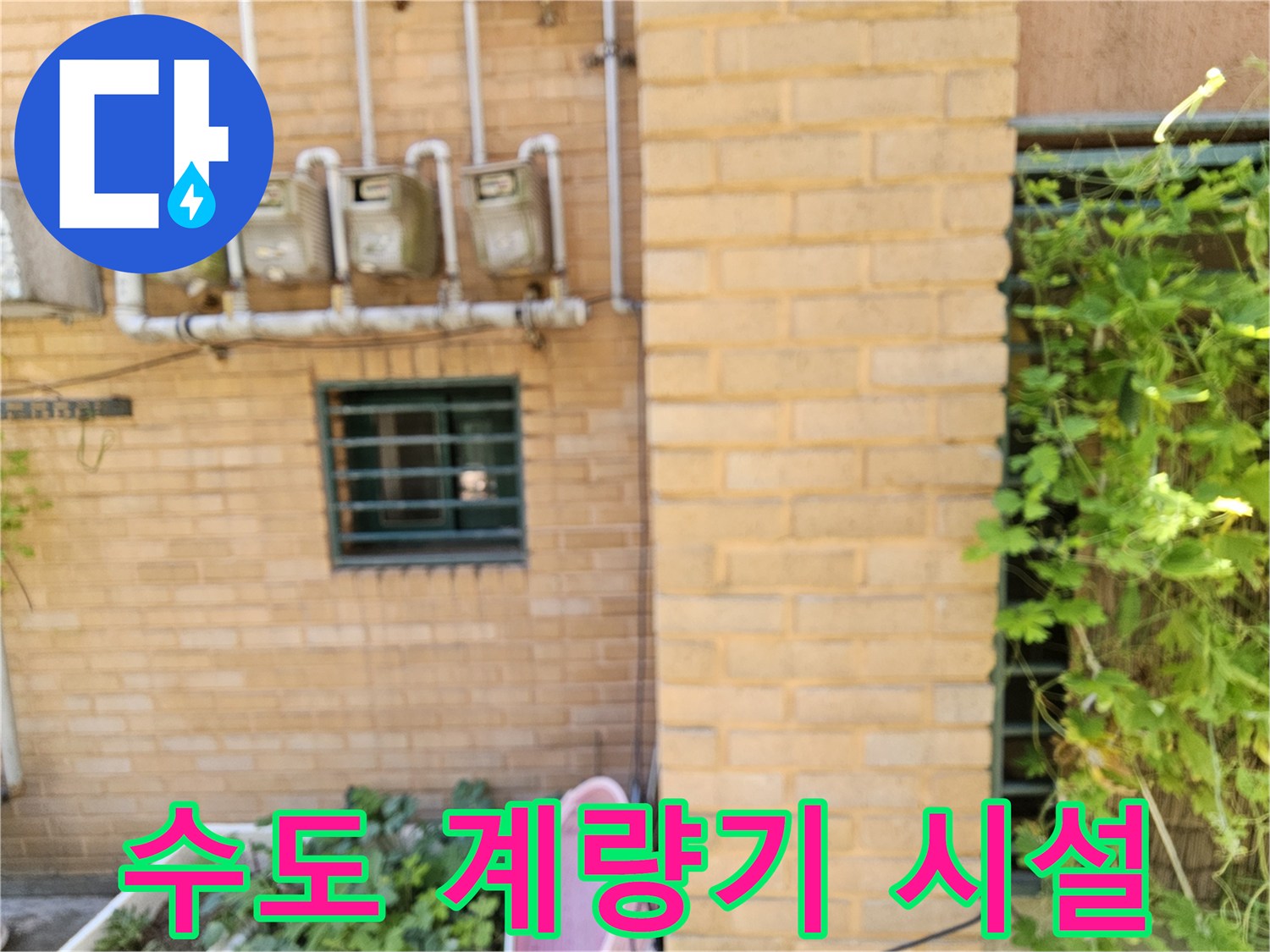 외벽 벽돌 사이의 수도 계량기와 배관 구조