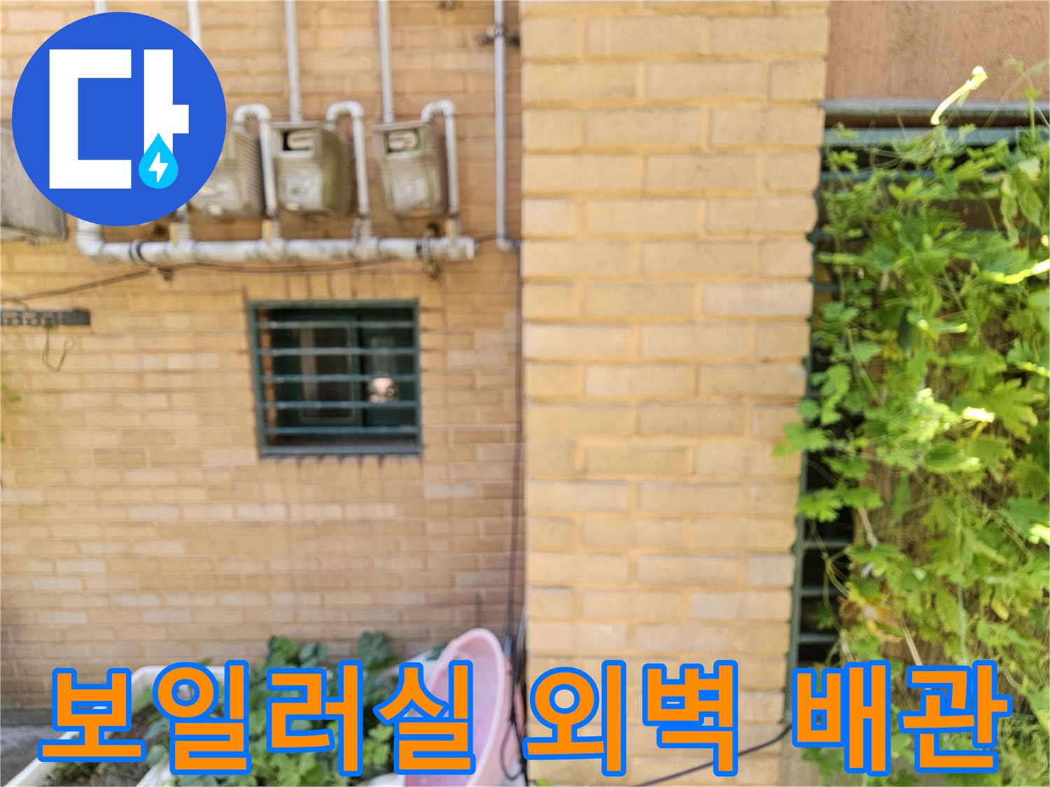 외벽에 설치된 수도 계량기와 연결된 흰색 배관들