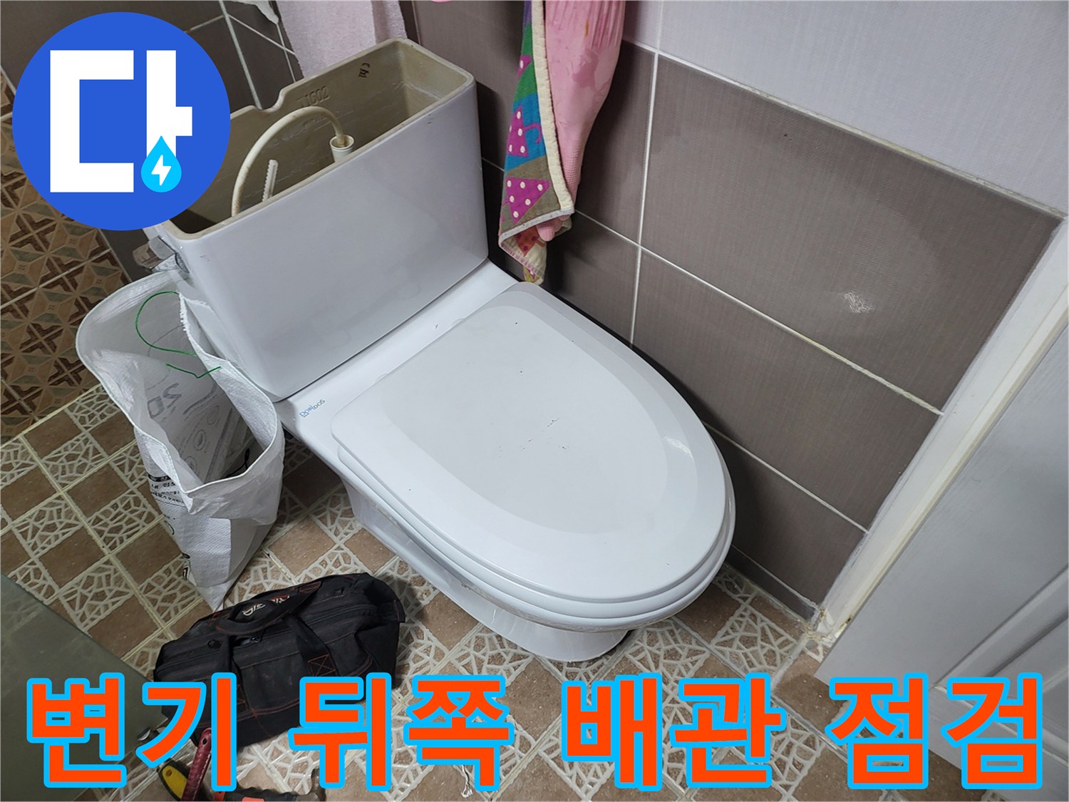 변기 하단과 벽면 타일 경계 부분을 확인하는 모습