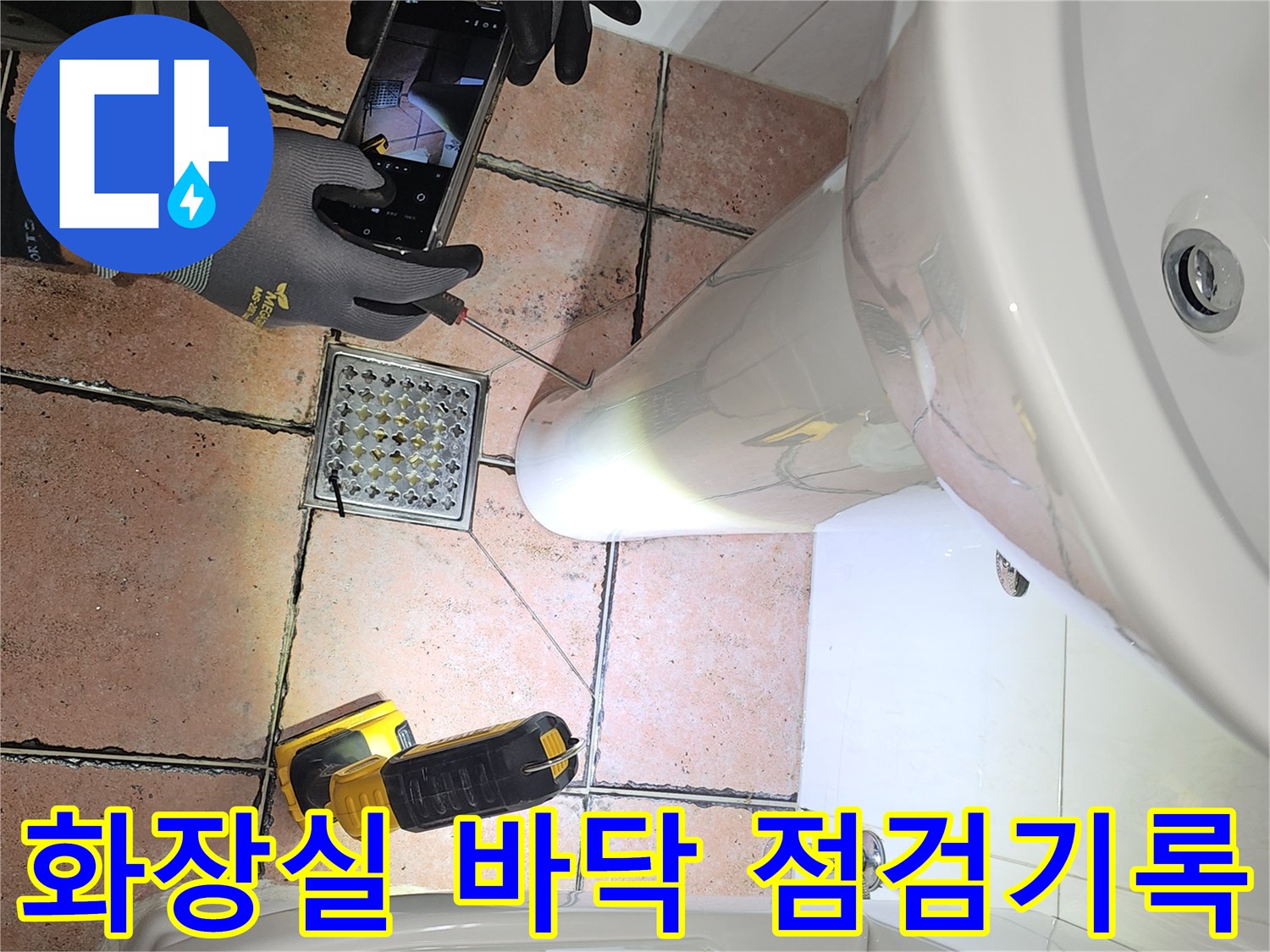 배수구 유가 주변의 타일 상태를 상세히 촬영하는 모습