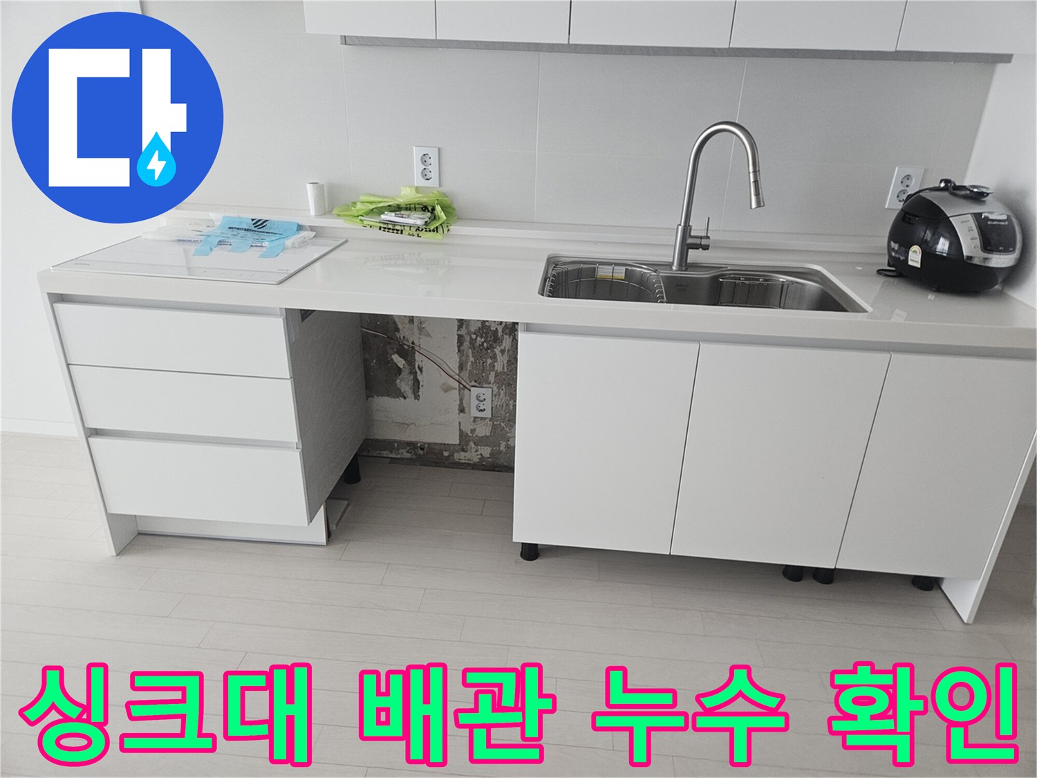 주방 싱크대 하부장 내부의 훼손된 호스와 물기가 맺힌 배관 모습