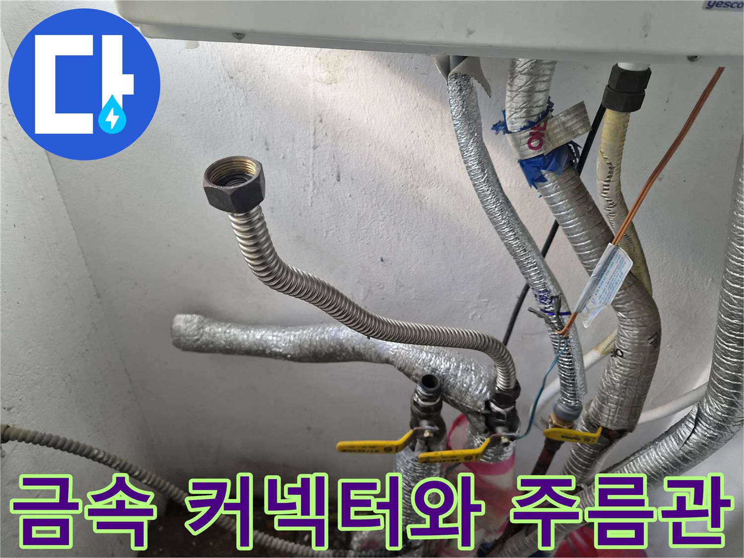보일러 하부의 금속 커넥터와 은색 주름관 노출 사진