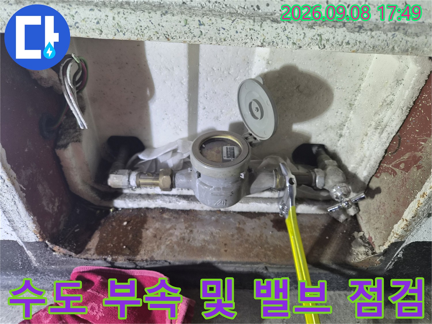 수도 계량기와 금속제 연결 배관의 상세한 모습을 담은 사진입니다.