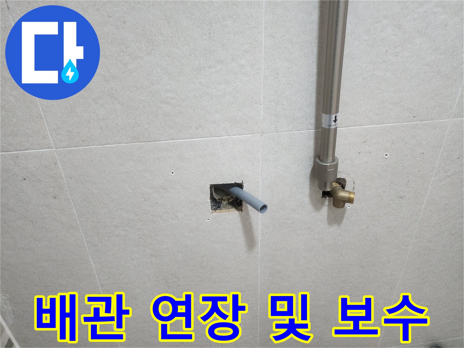 벽면 타일 사이로 돌출된 은색 수전용 배관과 황동 연결부