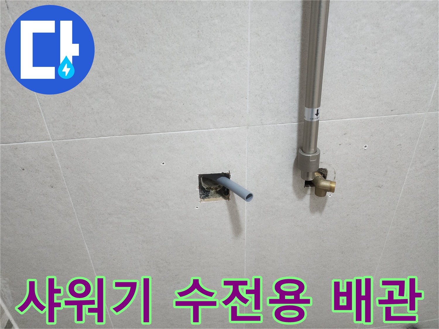 타일 벽면에서 밖으로 돌출된 은색 스테인리스 배관과 연결부