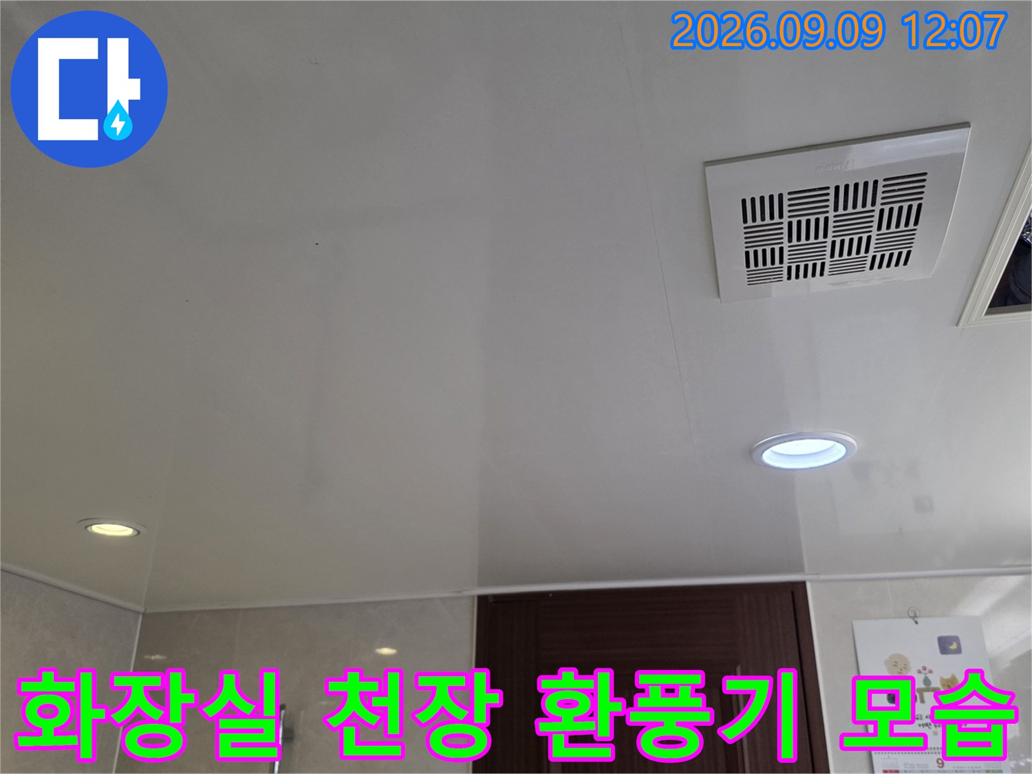 매립형 조명과 함께 설치된-욕실 천장 환풍기의 근접 사진입니다.