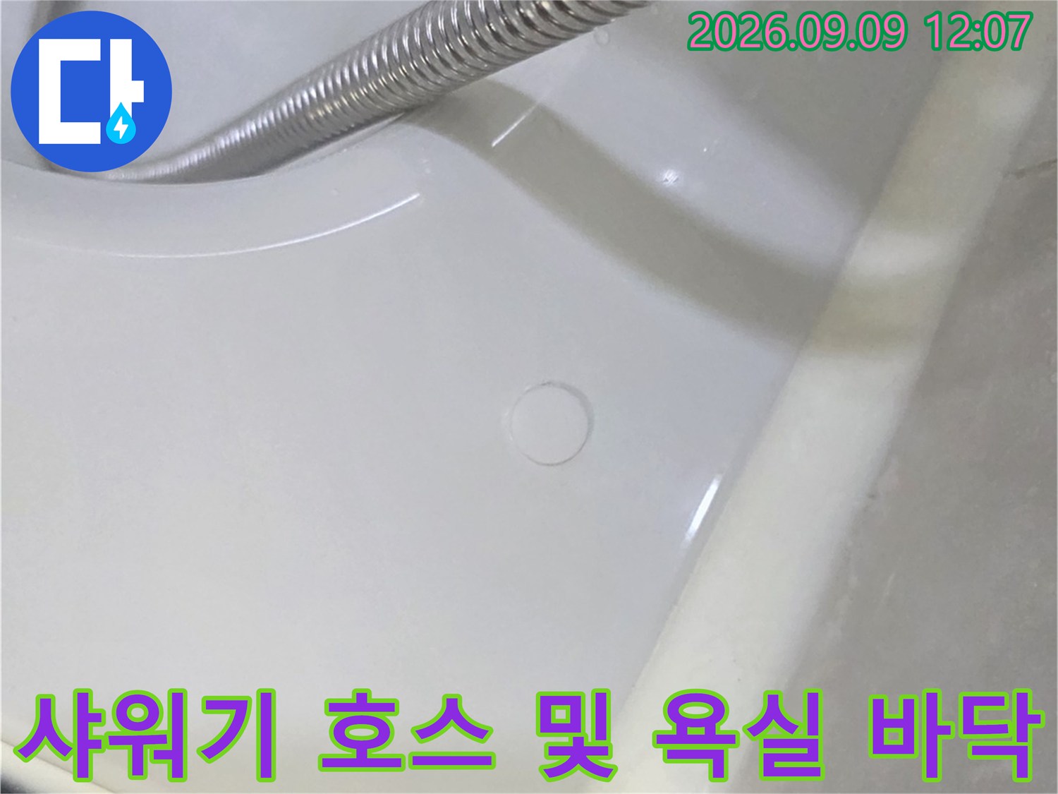 흰색 도기와 은색 샤워 호스가 맞닿은 지점