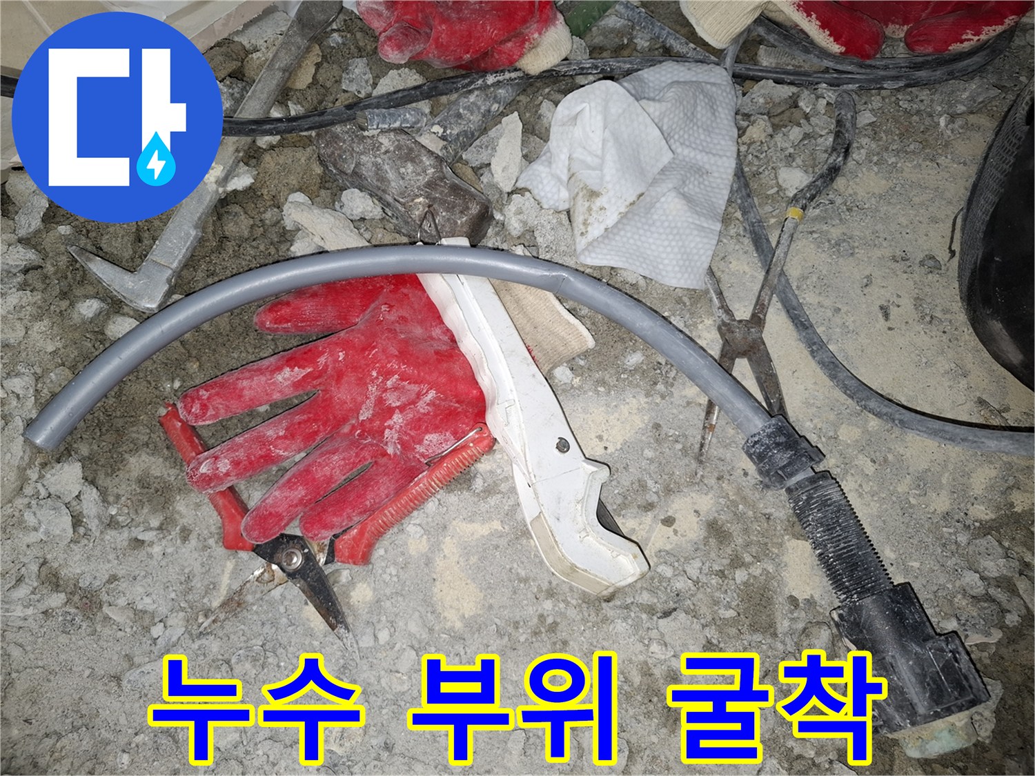 공사 중인 바닥의 회색 배관과 공구들