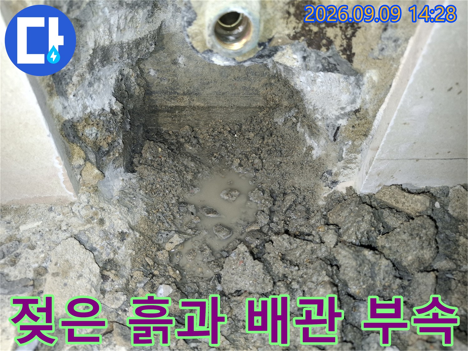 물에 젖은 토사와 노출된 배관 연결 부위