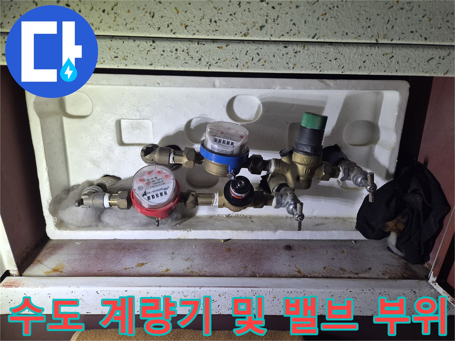 배관 연결부와 수도 계량기의 근접 촬영 사진