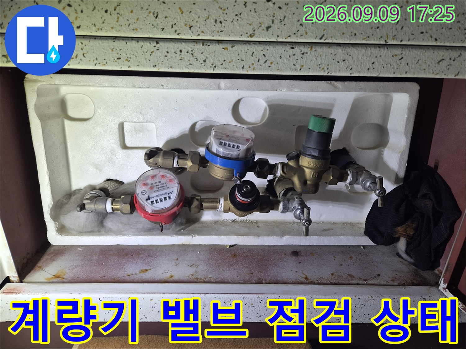 수도 계량기와 여러 개의 밸브가 모여 있는 계량기함 내부 사진입니다.