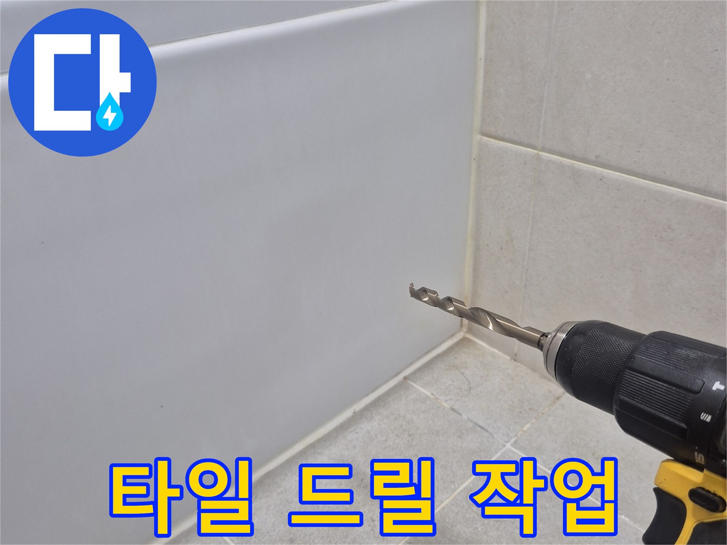전동 공구를 사용하여 타일 끝부분을 타공하는 모습입니다.