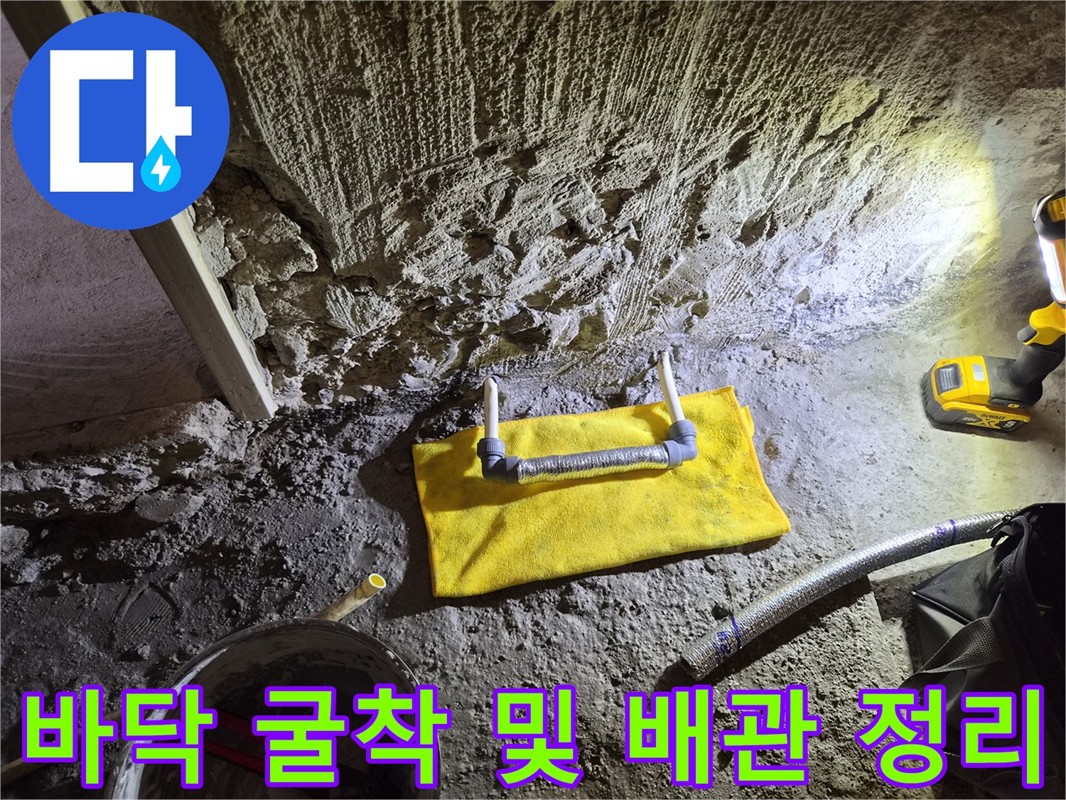 공사 중인 바닥의 거친 콘크리트 면과 노출된 배관 부품