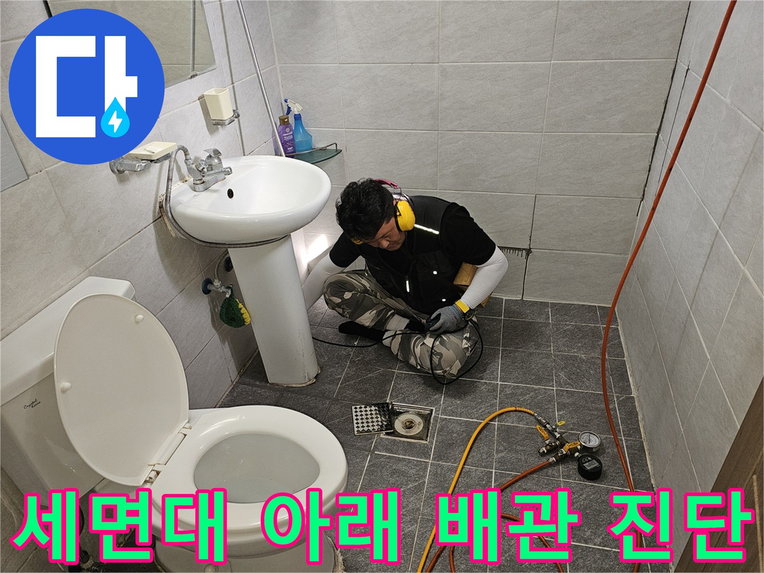 세면대 하부 공간에서 진행 중인 수도 배관 압력 검사 작업