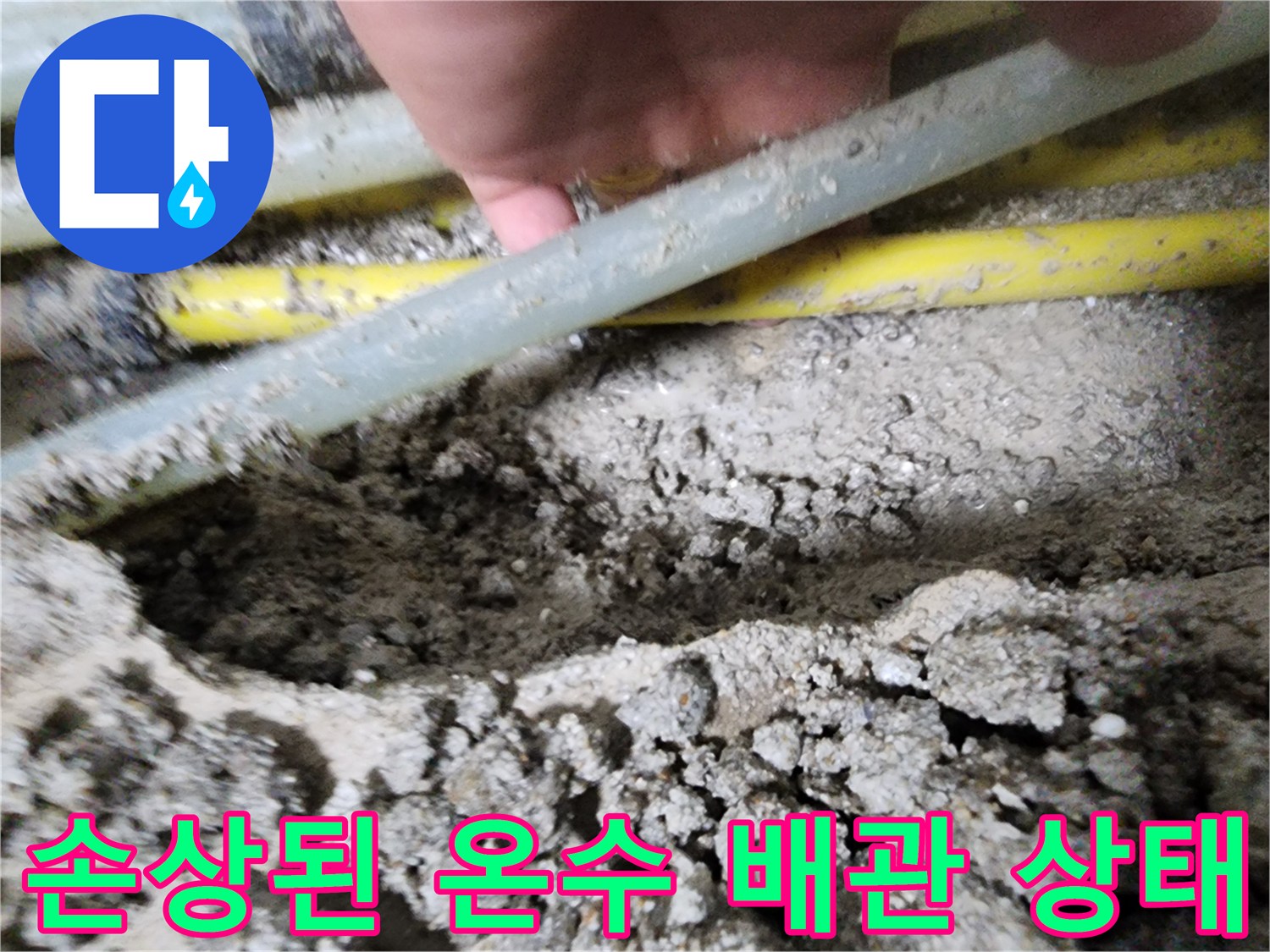 흙 속에 드러난-파손된 노란색 및 흰색 배관