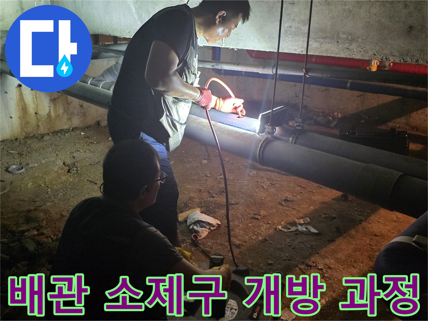 배관 내부의 슬러지를 제거하기 위해 소제구를 여는 작업 중입니다.