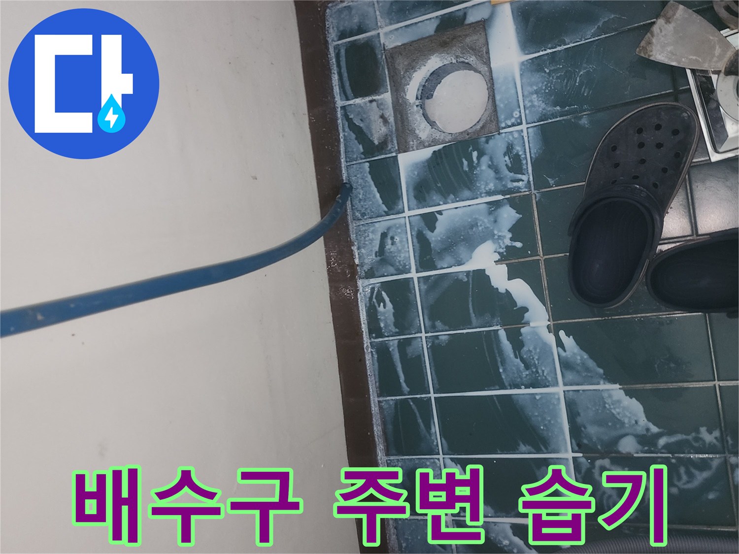 물기가 고여 있는 세탁실 배수구와 젖은 타일 표면