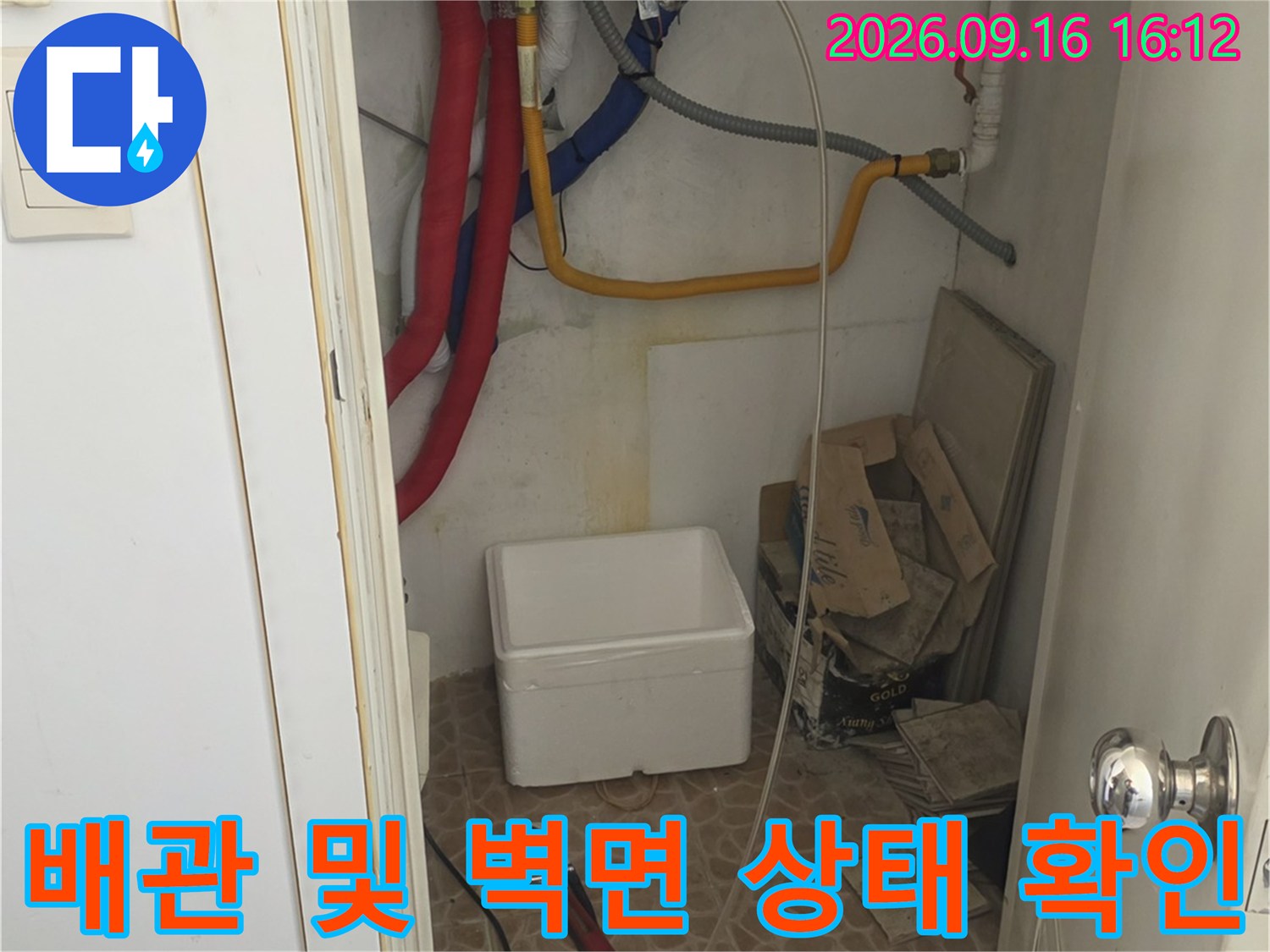 벽면에 연결된 배관과 바닥 쪽의 보온재 마감 부위를 촬영한 모습입니다.