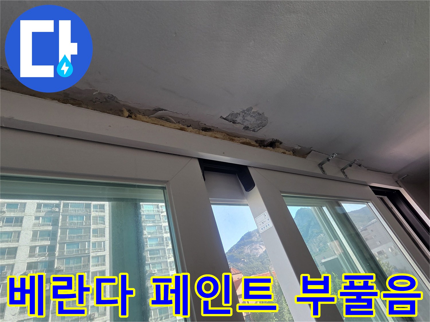 창문 프레임 위쪽 천장의 페인트 박리와 콘크리트 노출 상태