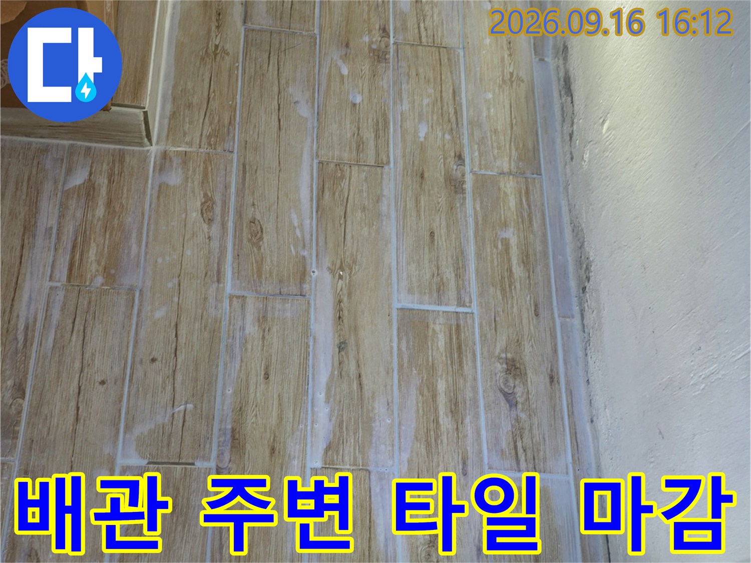 흰색 배관이 연결된-베이지색 타일 벽면 모습