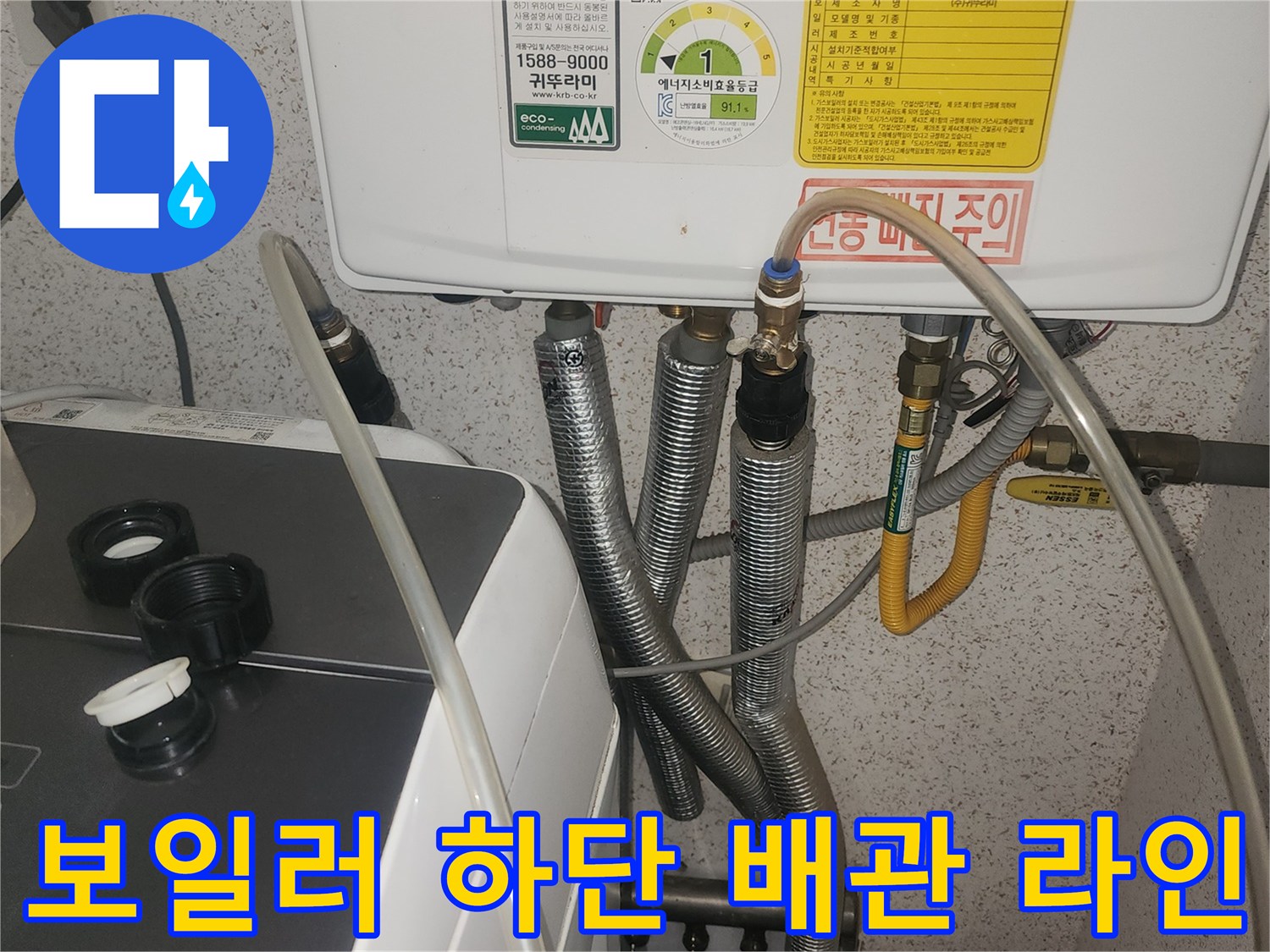 보일러 아래쪽으로 연결된 은색 및 노란색 배관들