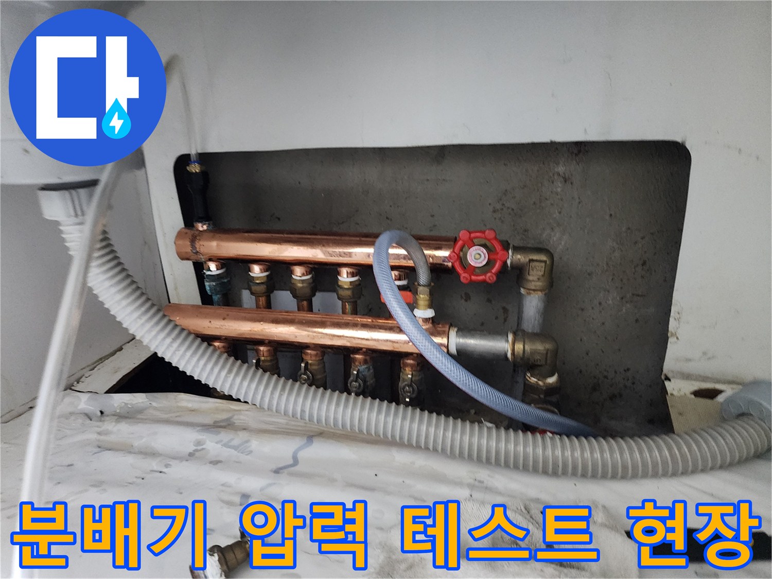 난방 분배기와 연결된 압력 측정 장비와 호스