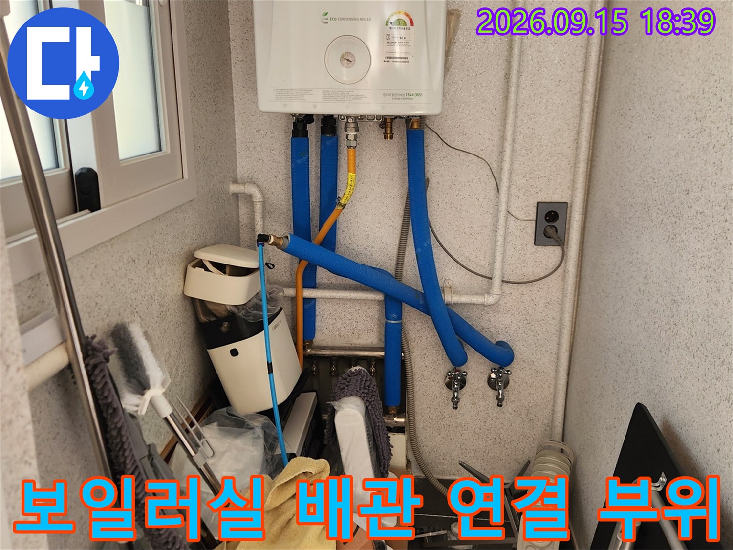 보일러 아래쪽으로 복잡하게 연결된 파란색 배관과 밸브의 모습