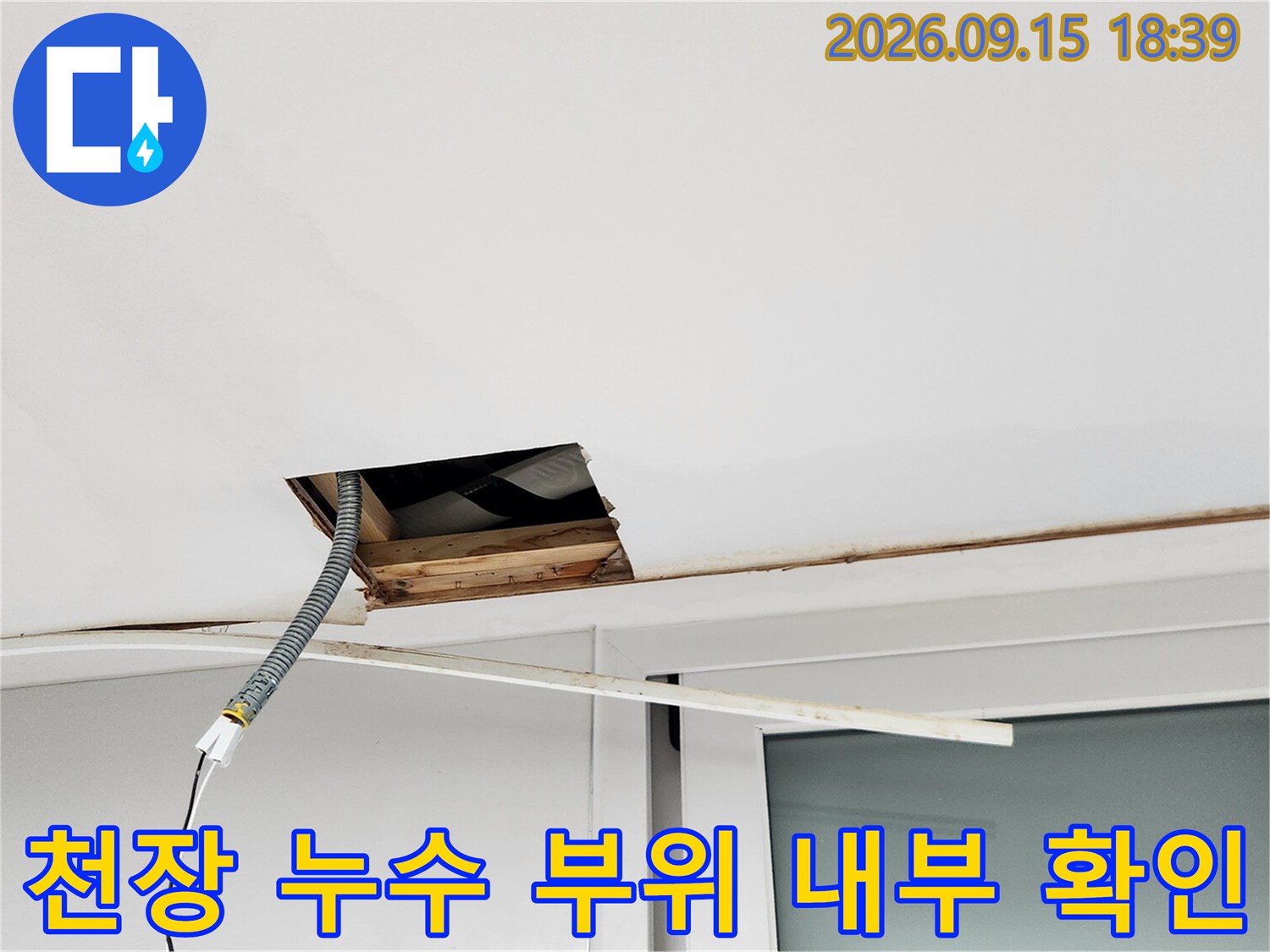 천장 점검구를 개방하여 배관 주변의 상태를 조사하는 모습입니다.