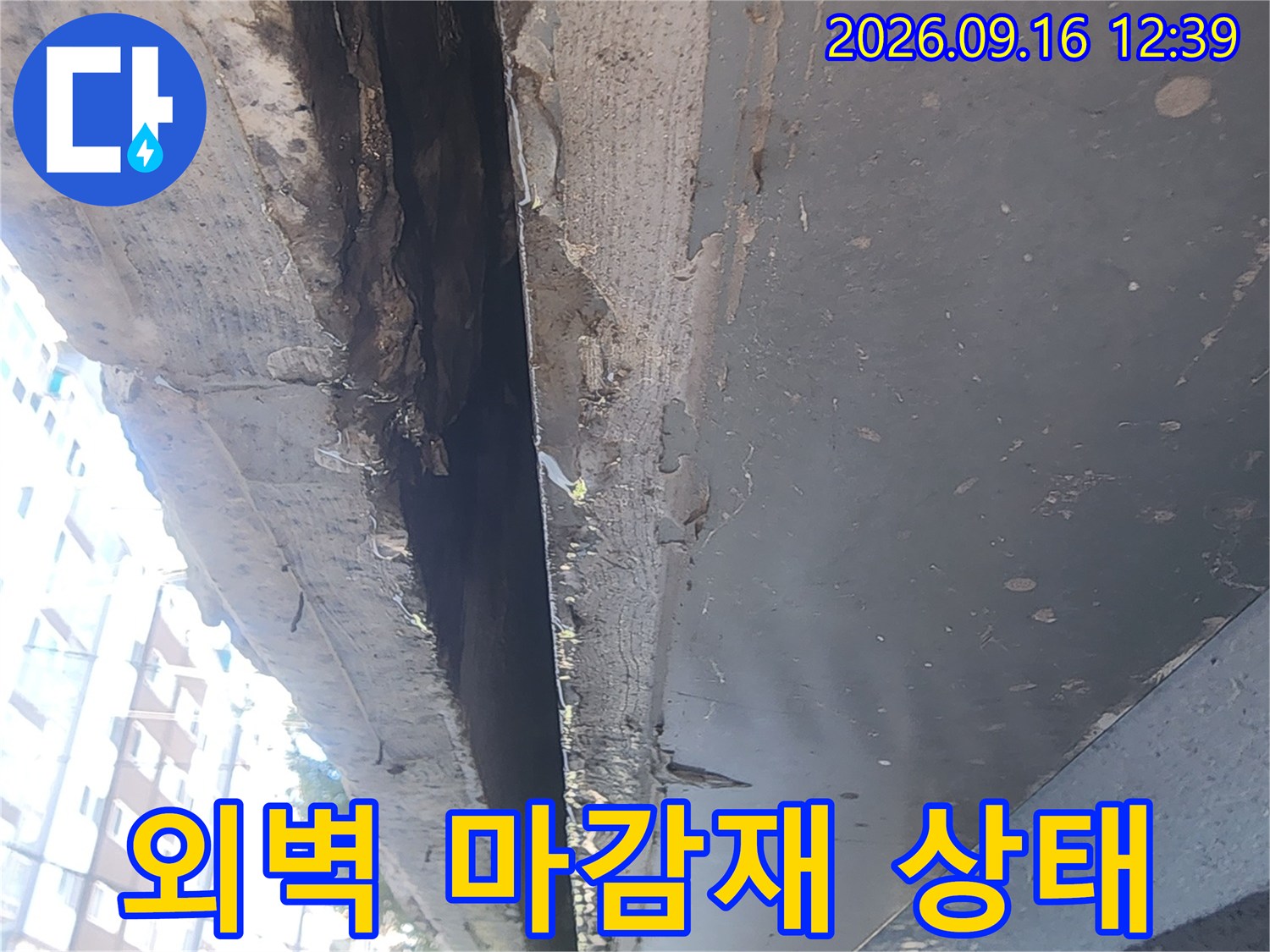 건물 외부 벽면의 마감재 탈락과 균열이 보이는 근접 사진