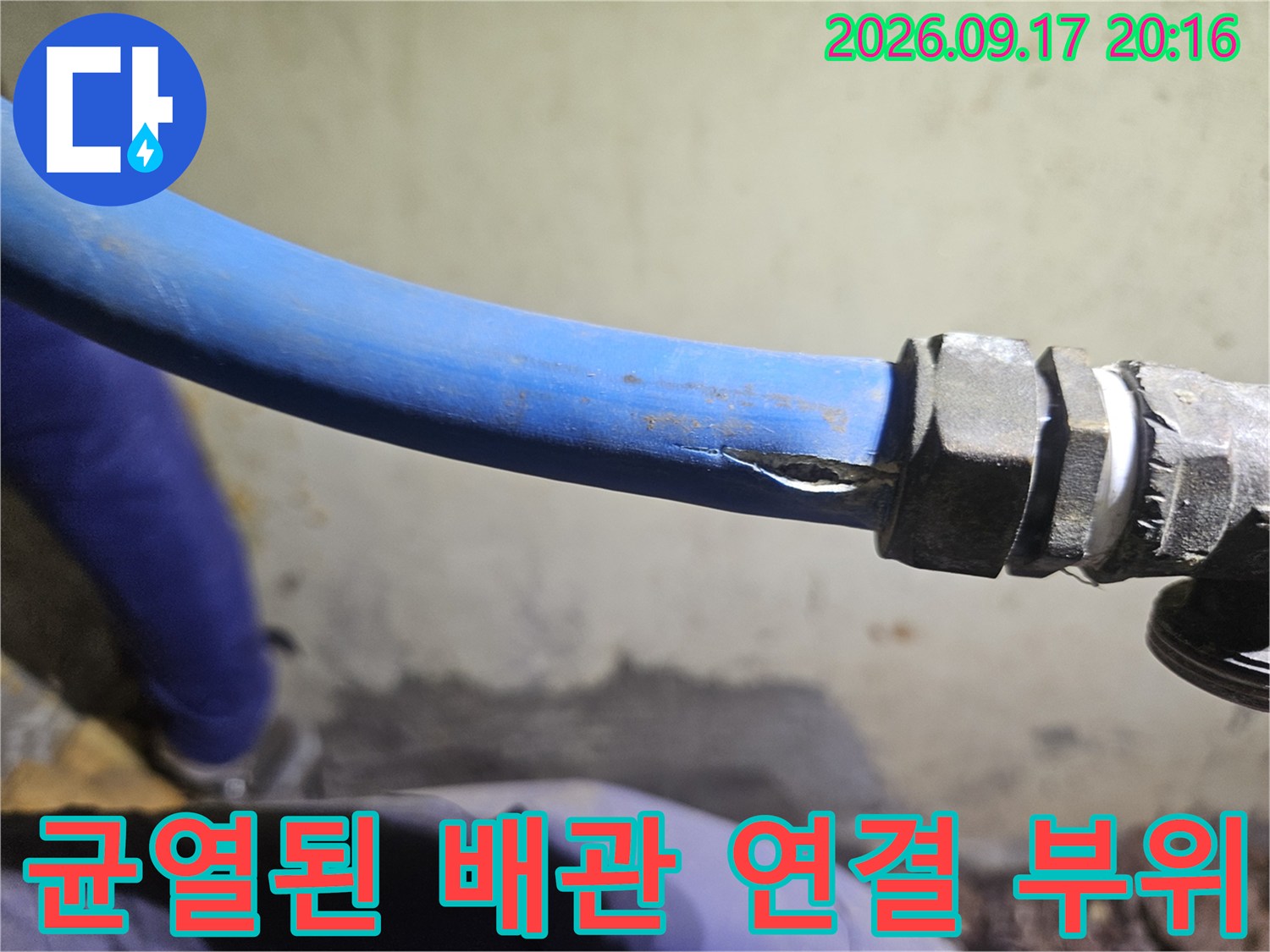 금속 부속에 연결된 파란색 배관의 찢어진 균열