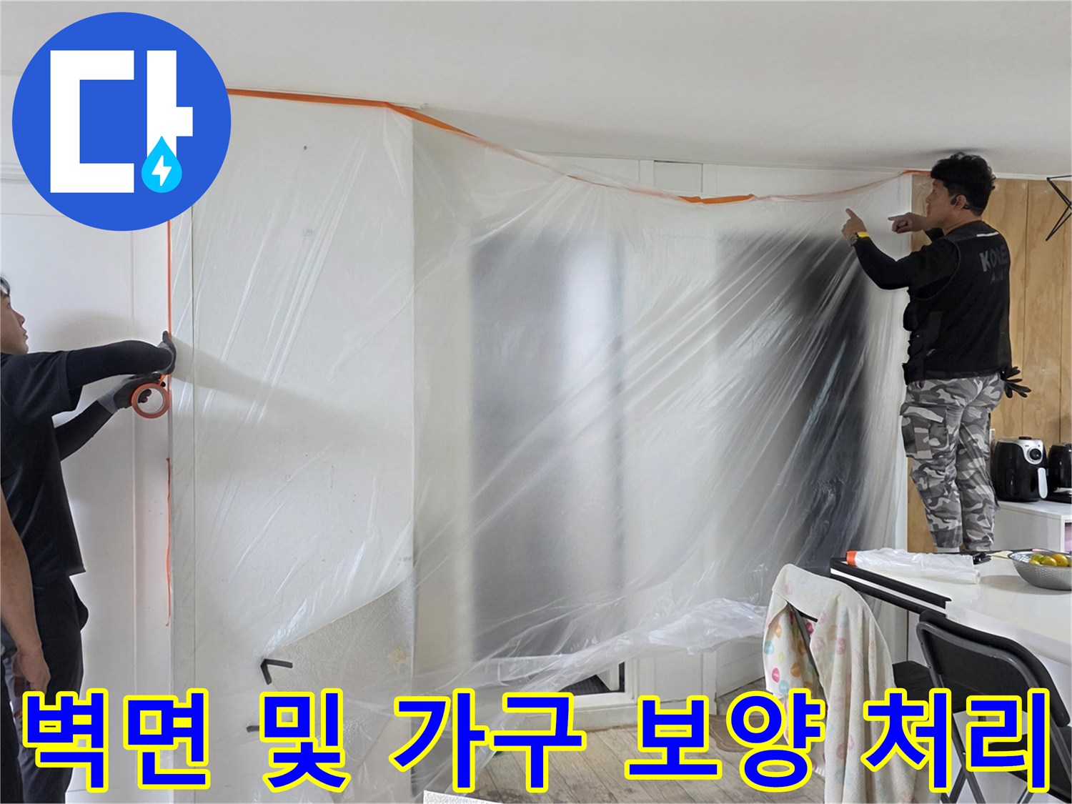 거실 벽면과 주변 집기를 비닐로 감싸 먼지 유입을 차단한 모습-배관 수리 현장 관리