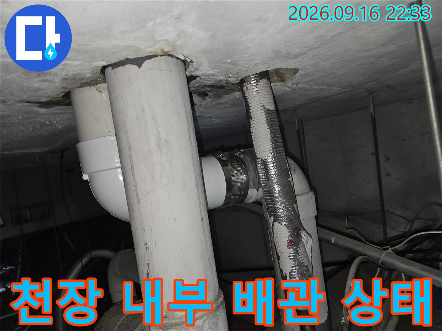 천장 점검구 내부의 노출된 배관과 누수 흔적