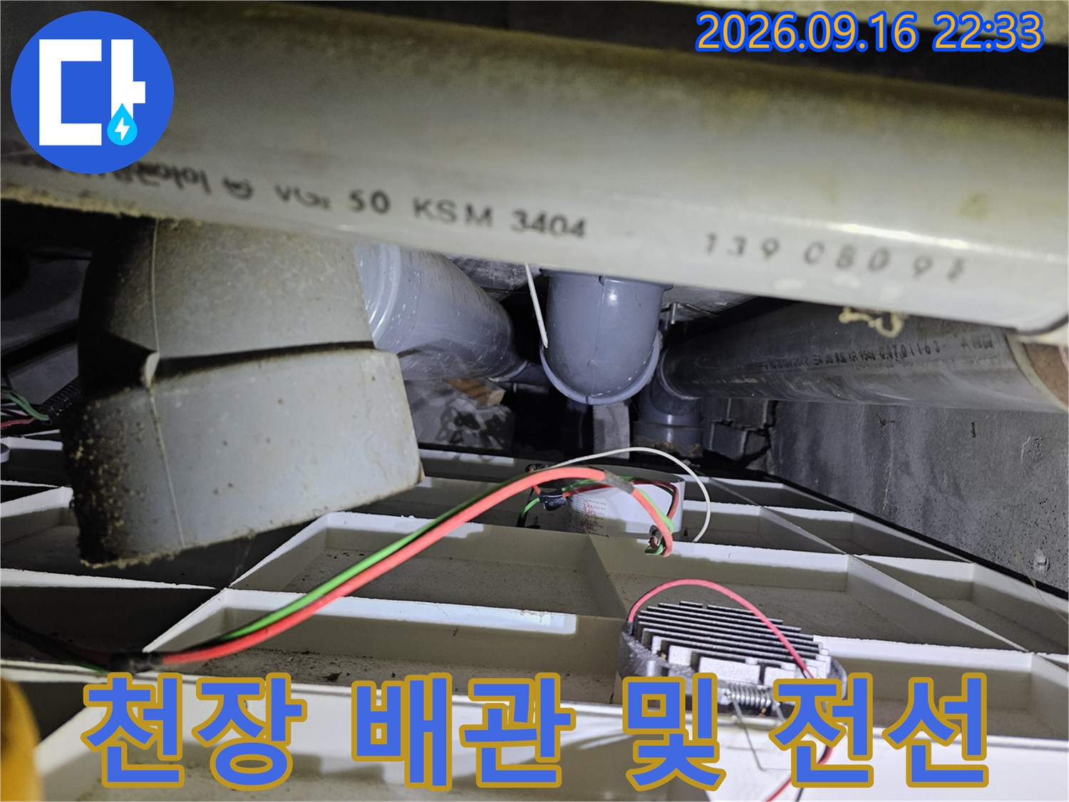천장 점검구를 통해 본 배관과 전기 배선의 모습