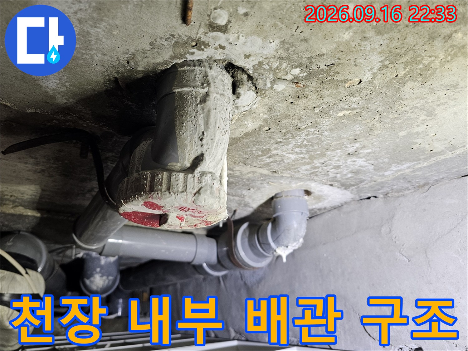 천장 콘크리트 사이로 연결된 하수관과 배관 부속품 상세 이미지입니다.