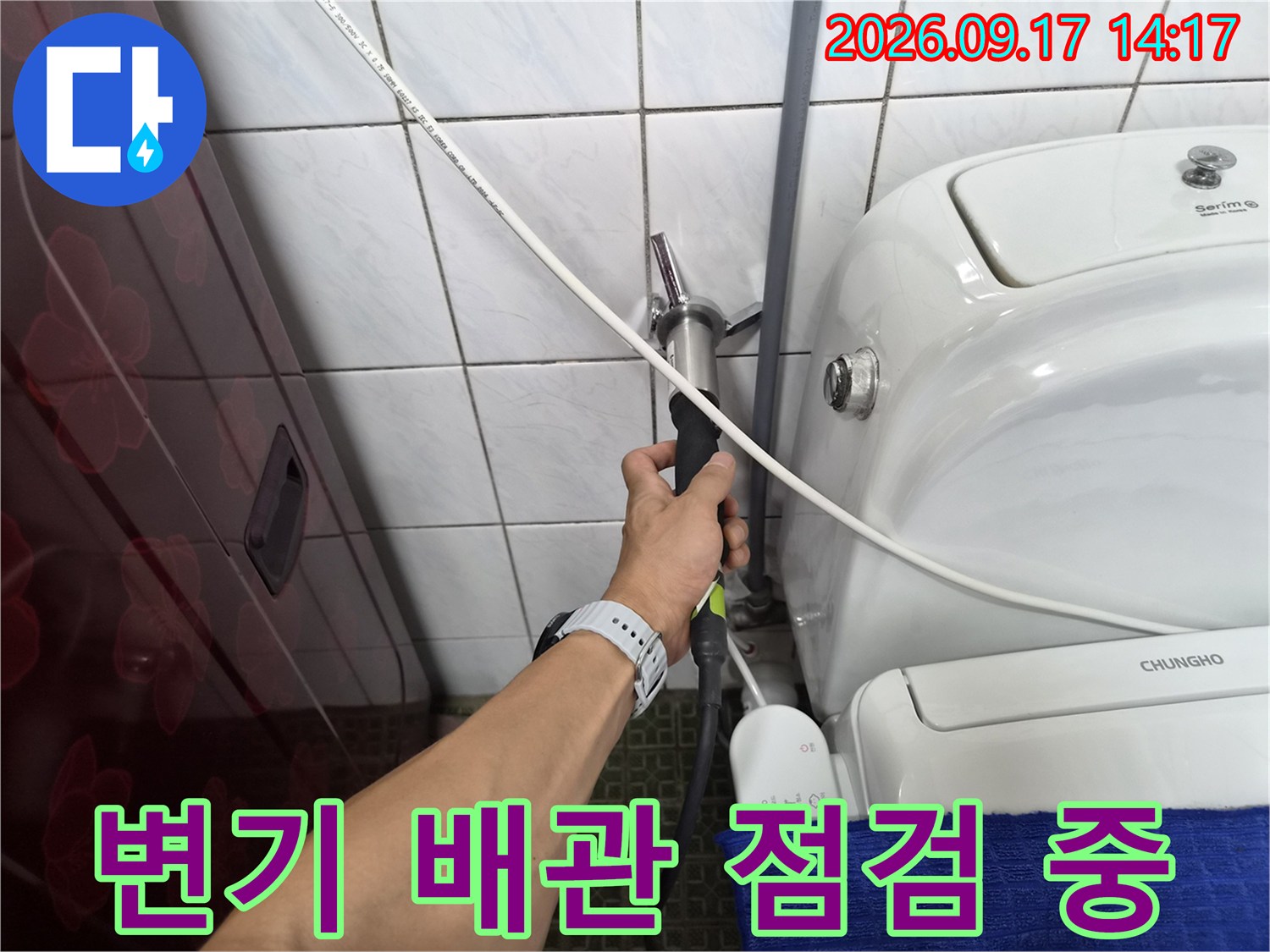 변기 옆 수도 밸브와 배관 연결 부위를 손으로 점검하는 모습