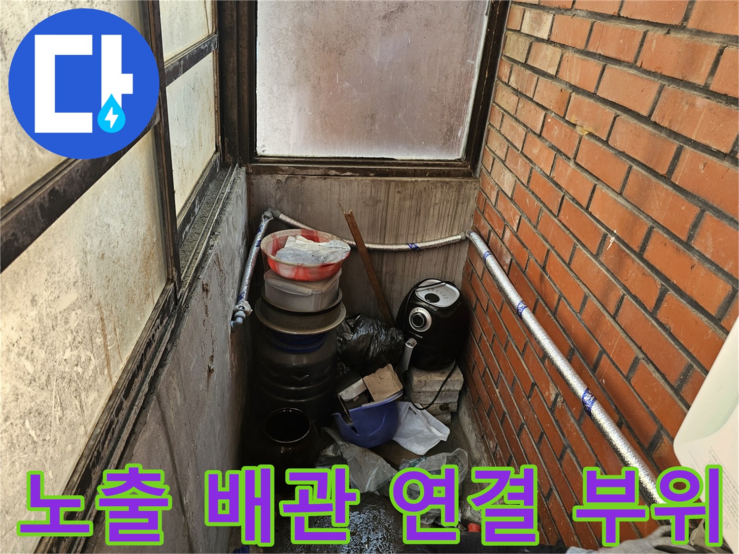 벽돌 벽과 외벽 노출 배관의 접합 부분 사진입니다.